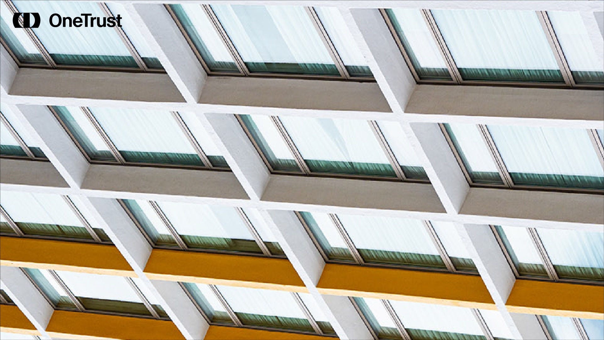 A repeating architectural pattern of angled glass windows and white structural beams.