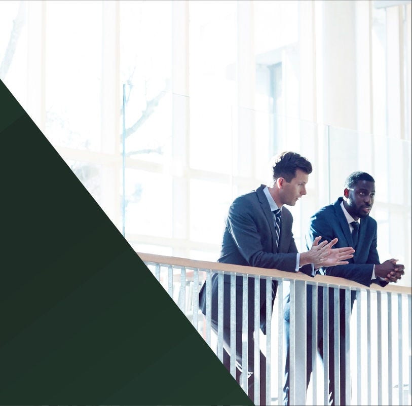 Two businessmen chatting at a balcony railing