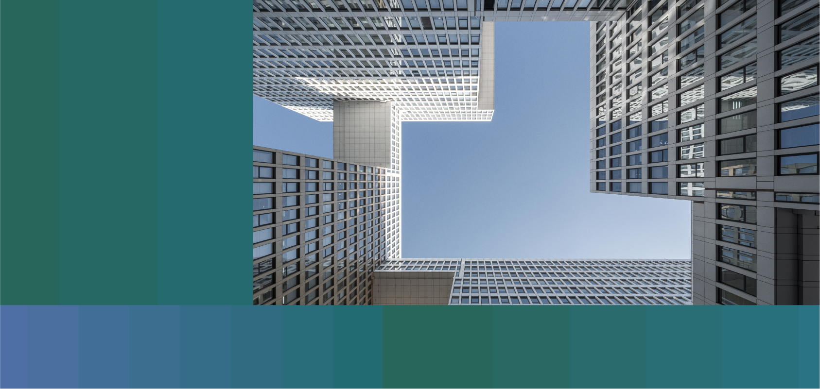 photo of skyscrapers connected by skywalks. The viewer is looking up at the skyscrapers from ground level so that the blue sky can be seen between them.