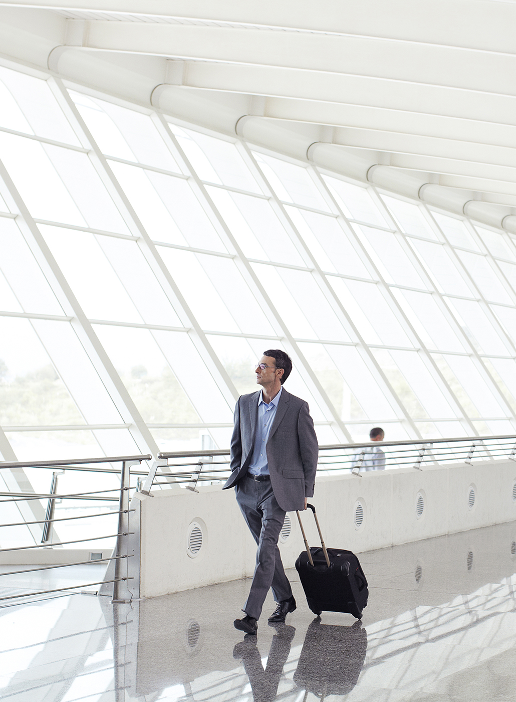 Businessman walking through an airport with his luggage.