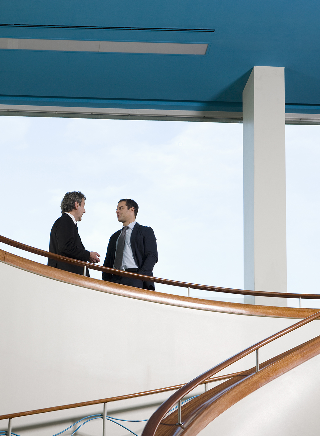 Deux hommes d’affaires discutant sur une mezzanine.